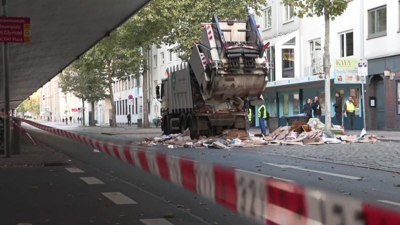 Ein Müllwagen wird auf der Straße entleert.