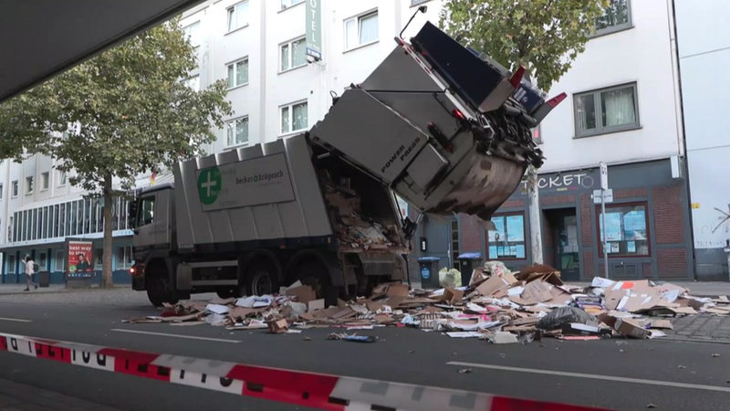 Ein Müllwagen wird auf der Straße entleert.