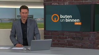 Moderator János Kereszti im Studio von buten un binnen.