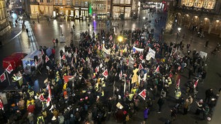 Eine Gruppe Menschen demonstriert im Dunkeln vor dem Bremer Rathaus