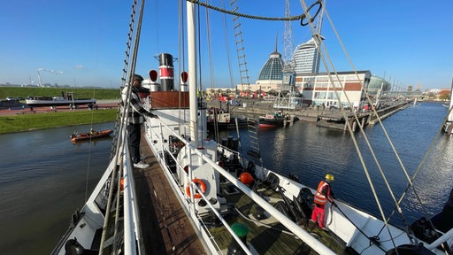 Ein Schiff fährt durch einen Hafen.