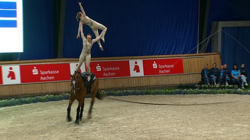 Zwei Mädchen stehen auf einem Pferd bei der Voltigier Weltmeisterschaft.