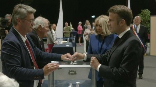 Der Französische Präsident Emanuel Macron beim Einwurf seines Stimmenzettels in eine Wahlurne.