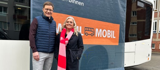 Felix Krömer und Anja Görz am Wahlbus von buten un binnen