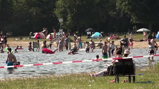 Viele Menschen schwimmen in einem See.