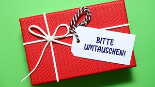 Ein eingepacktes Geschenk mit dem Schild "Bitte umtauschen"