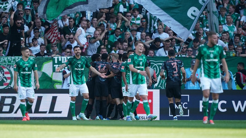 Werder-Spieler gehen frustriert über den Platz.