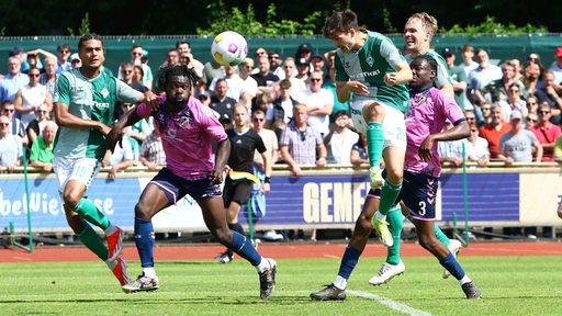 Ein Werder-Spieler köpft im Spiel gegen Altona 93 den Ball aufs Tor.