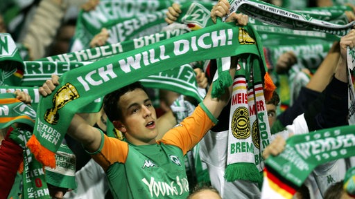 Ein Werder-Fan hält einen Schal mit der Aufschrift "Ich will dich". 