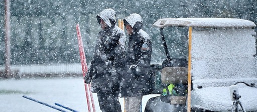 Peter Niemeyer und Clemens Fritz schauen vom Rand zu, als Werders Team im Schnee trainiert.