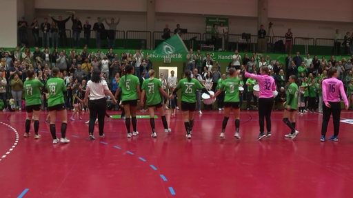 Die Werder Handball Frauenmannschaft nach einem Sieg in der Halle mit ihren jubelnden Fans.