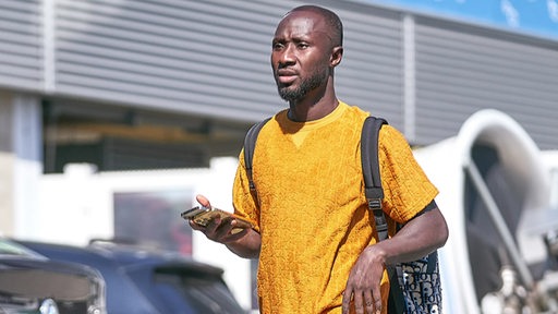 Naby Keita geht eine Straße entlang.