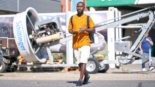 Naby Keita verlässt  in sommerlicher Kleidung das Weser-Stadion.