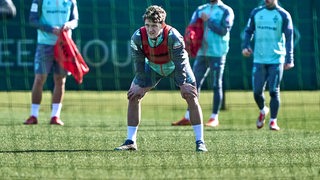 Jens Stage stützt sich im Training mit beiden Armen auf den Knien ab.