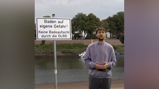 Ein junger Mann, Max Lange, steht vor einem Schild "Baden auf eigene Gefahr"