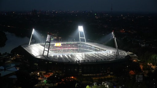 Zu sehen ist das Weserstadion bei Nacht mit aktivem Flutlicht.