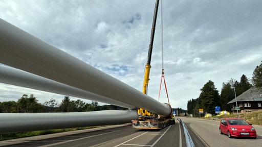 Die Rotoren einer Windkraftanlage liegen auf einem Selbstfahrer für den Transport bereit.