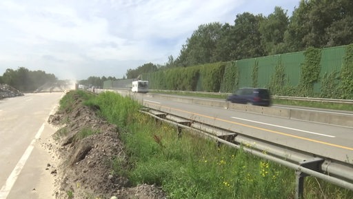 Autos fahren auf der Autobahn an einer Baustelle vorbei.