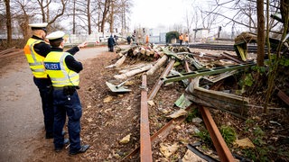 Polizisten stehen nach einem Zugunglück an der Unfallstelle.